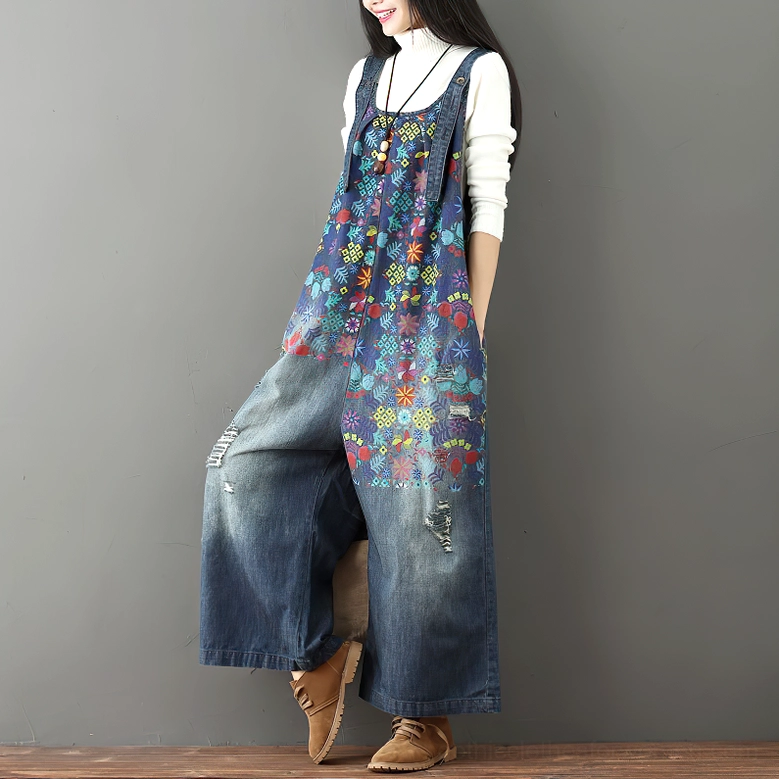 Right three-quarter view of distressed floral denim wide-leg overalls styled with brown leather boots, highlighting vintage aesthetic
