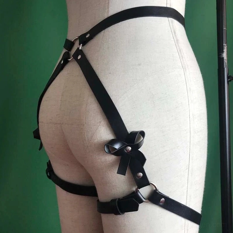 Black leather garter harness on display mannequin showing bowknot, metal rings, and adjustable leather bands