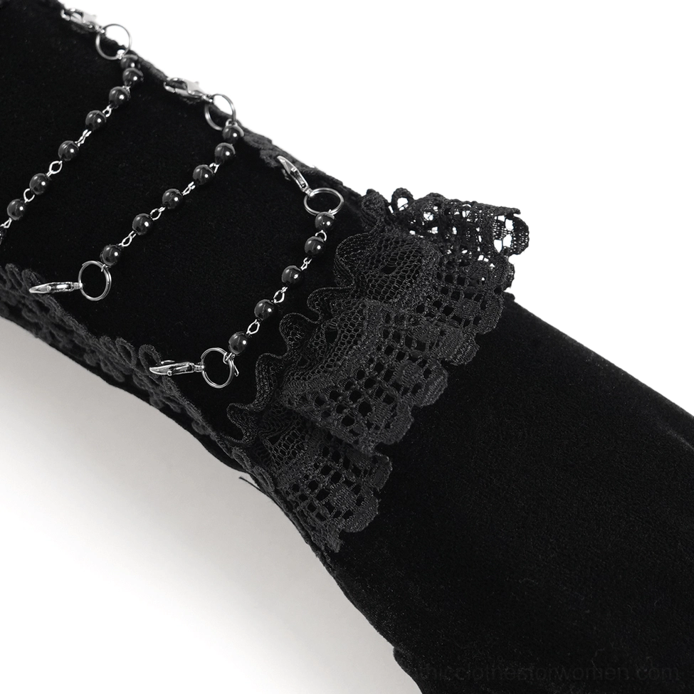 Top-view close-up of gothic opera glove side details showing black velvet fabric, metal chain hardware integration, and lace patch embellishment