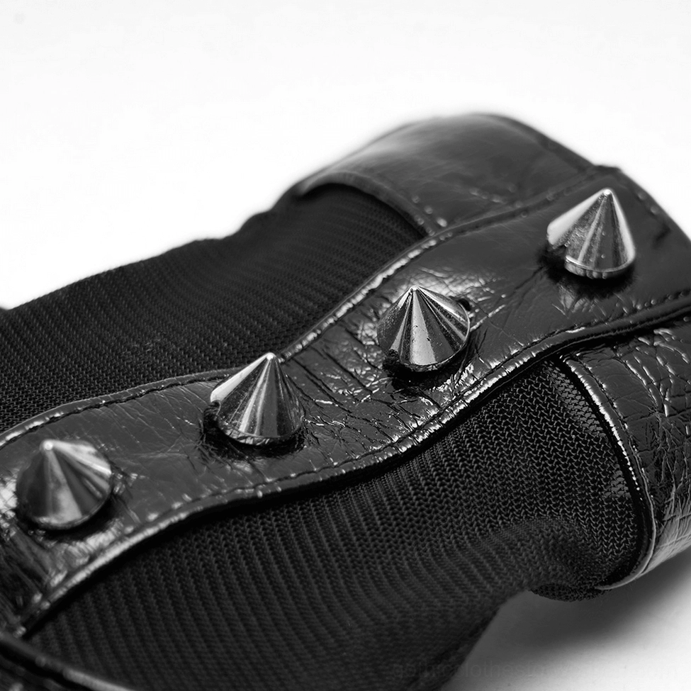 Extreme close-up macro view of conical metal spikes on gothic gloves showing mesh and PU leather materials