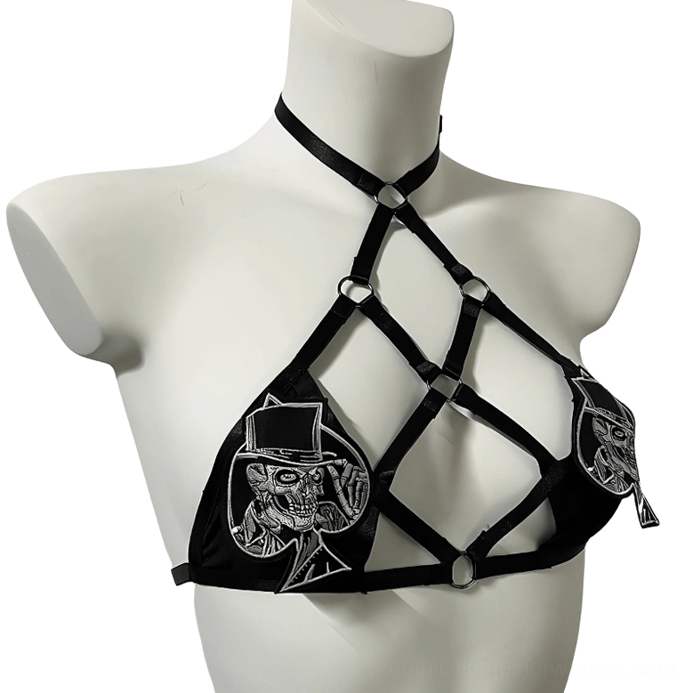 Crisscross hollow straps and silver skull embroidery patches on black gothic harness bra, side front three-quarter view