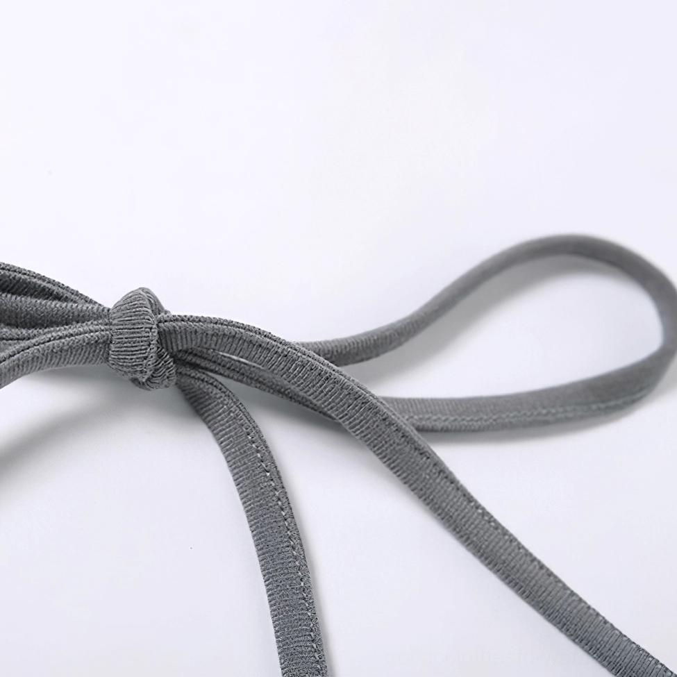 Macro close-up of halter strap elastic tie with knotted closure detail on grey gothic crop cami