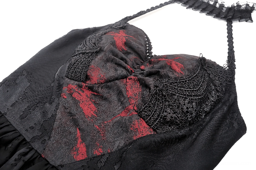 Close-up detail of gothic halter dress showing embossed lace fabric, red printed pattern, and halter strap attachment point