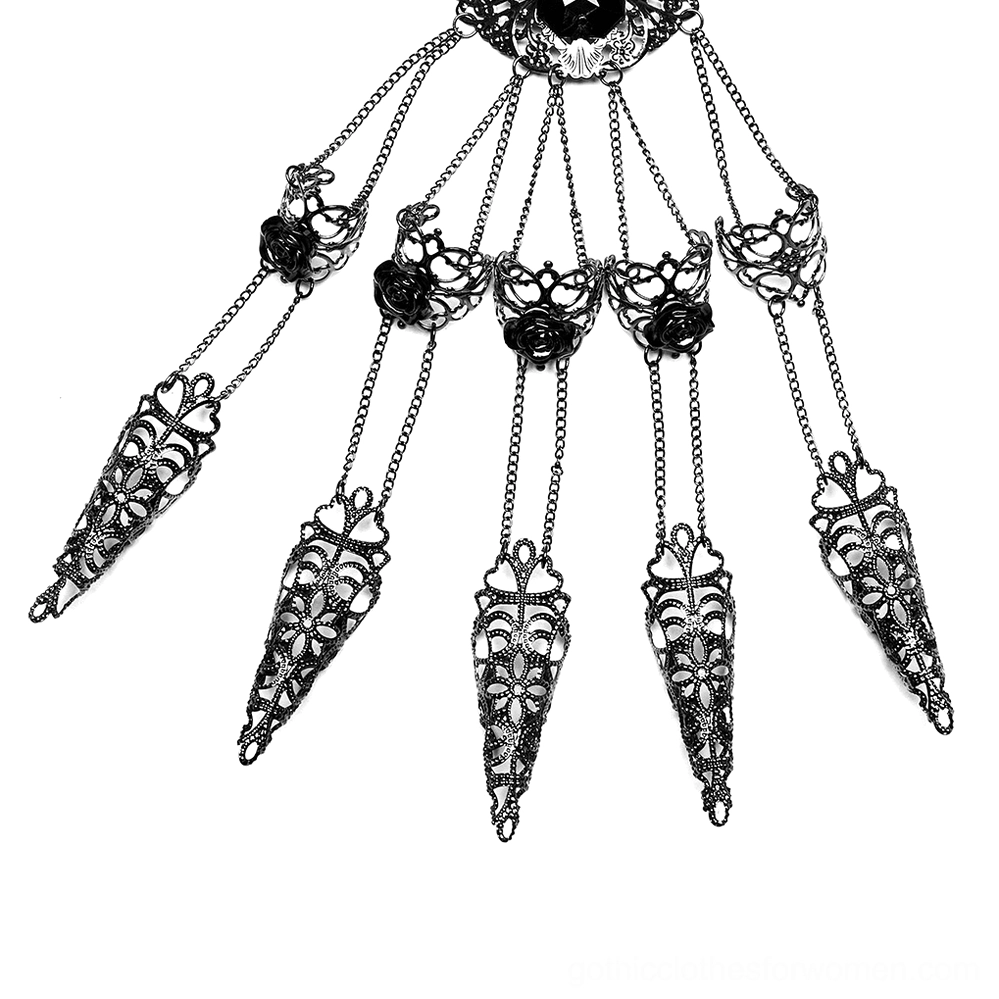 Top-down flat lay view of gothic hand chain jewelry featuring ornate filigree metal framework, rose accent details, interconnected fine chains, and central gemstone ornament