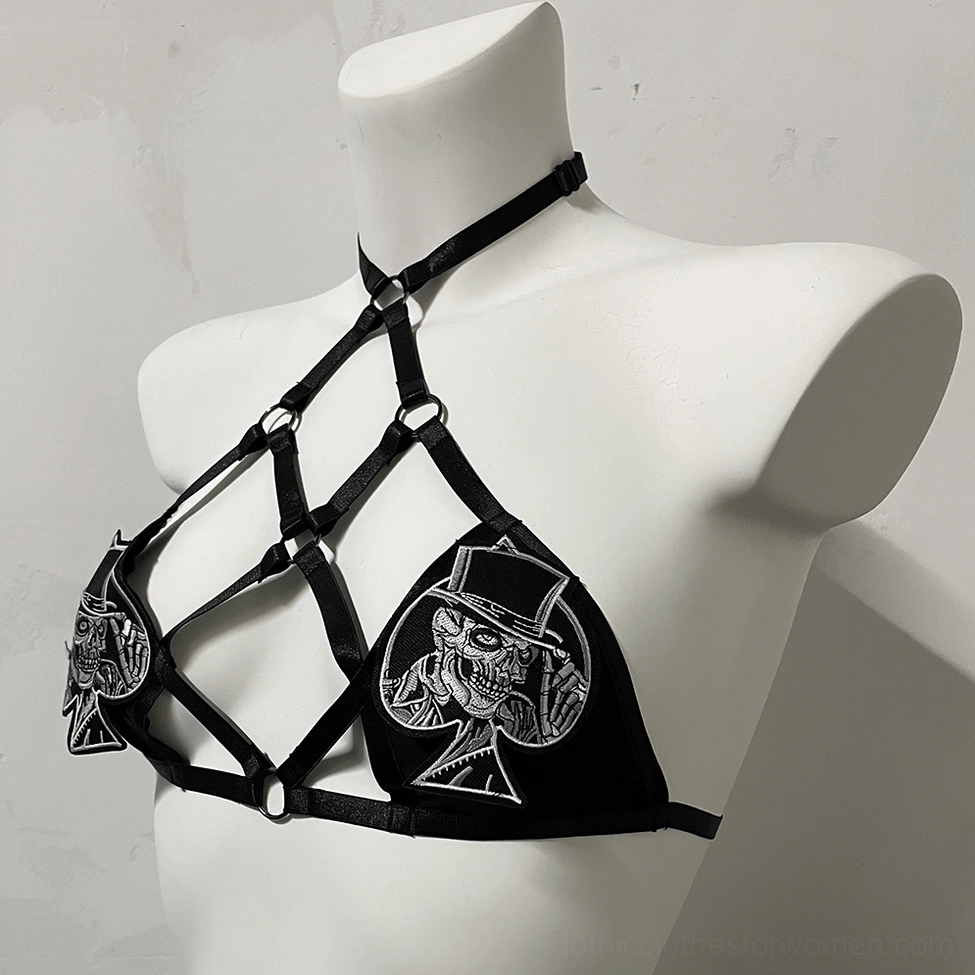 Top hat skull embroidery detail on black woven fabric straps of gothic adjustable harness bra, low side perspective