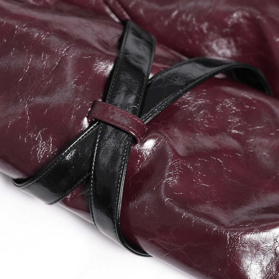 Gothic burgundy harness coat construction detail showing synthetic leather quality and decorative buckle fastening system