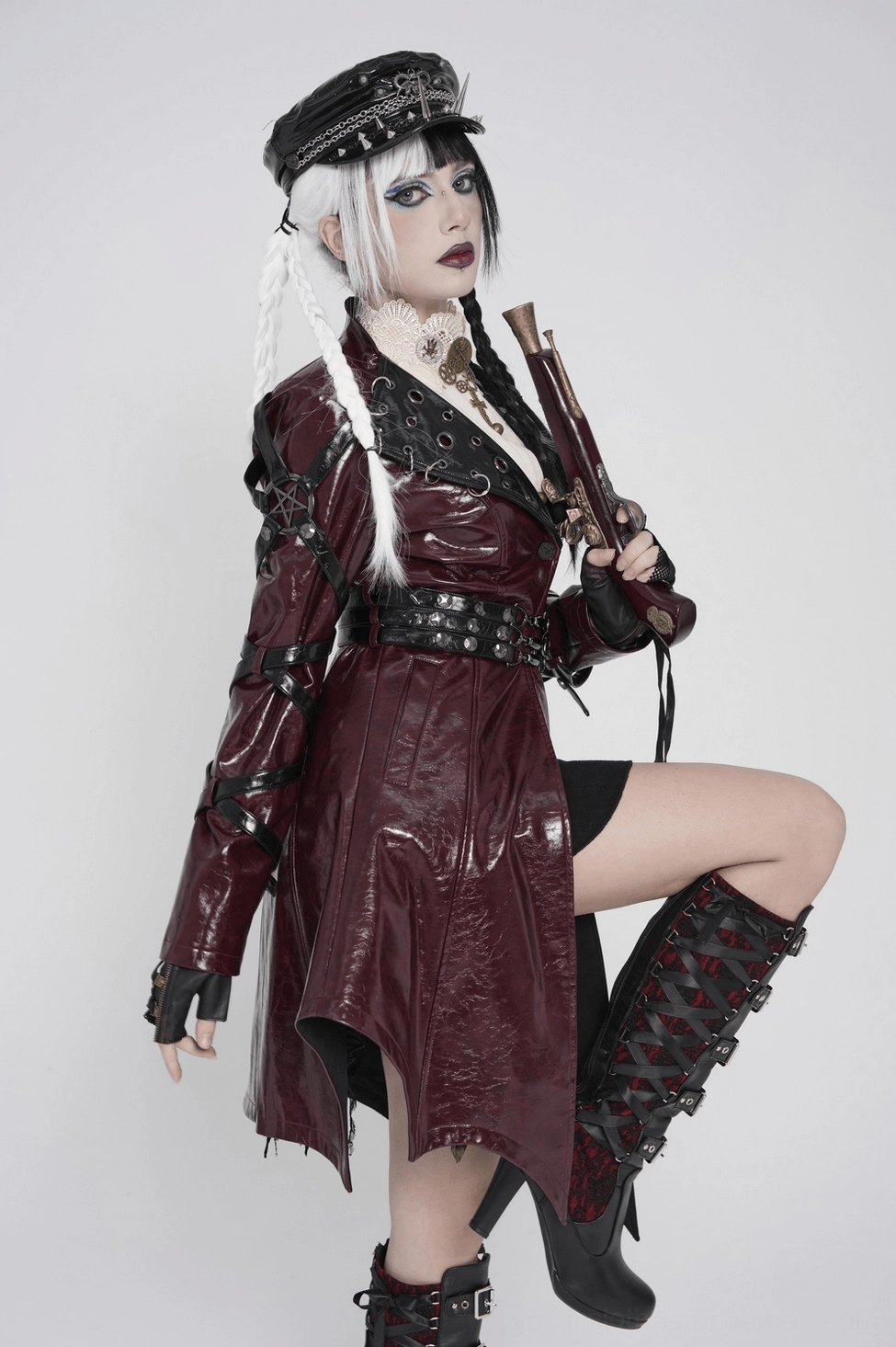 Side view of burgundy gothic harness long coat displaying length and asymmetrical hem silhouette on display mannequin