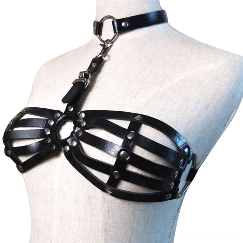 Close-up detail view of black leather harness showing polished metal D-rings, adjustable buckles, and industrial rivet construction