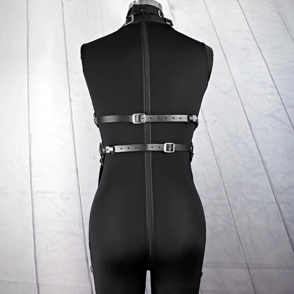 Detail shot of metal ring attachments and synthetic leather construction on gothic bondage harness with adjustable strap system