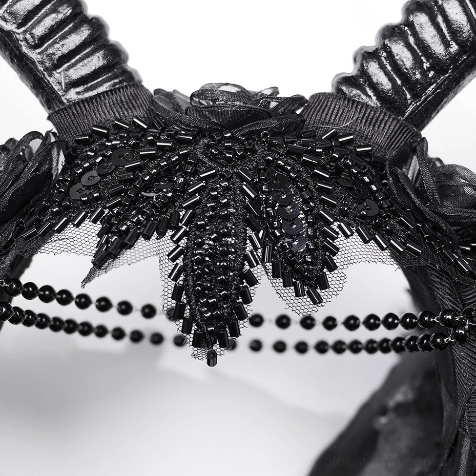 Close-up macro detail of gothic headpiece beaded chains, lace mesh, and sequin embellishments on black fabric