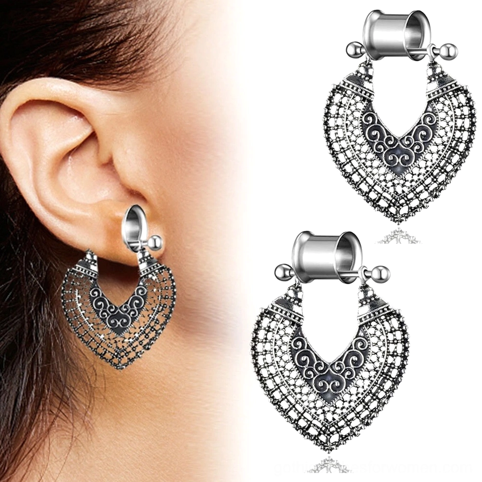 Single gothic heart tunnel earring with intricate filigree carving worn on female ear, side close-up view