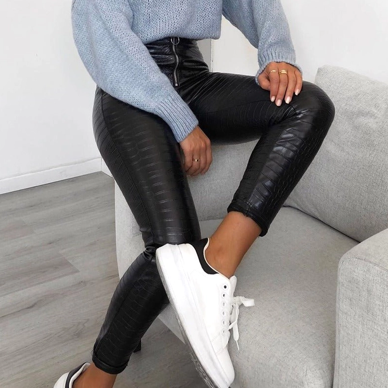 Model wearing black high-waist gothic faux leather pencil pants, detailed view of waist, O-ring zipper, and crocodile grain pattern