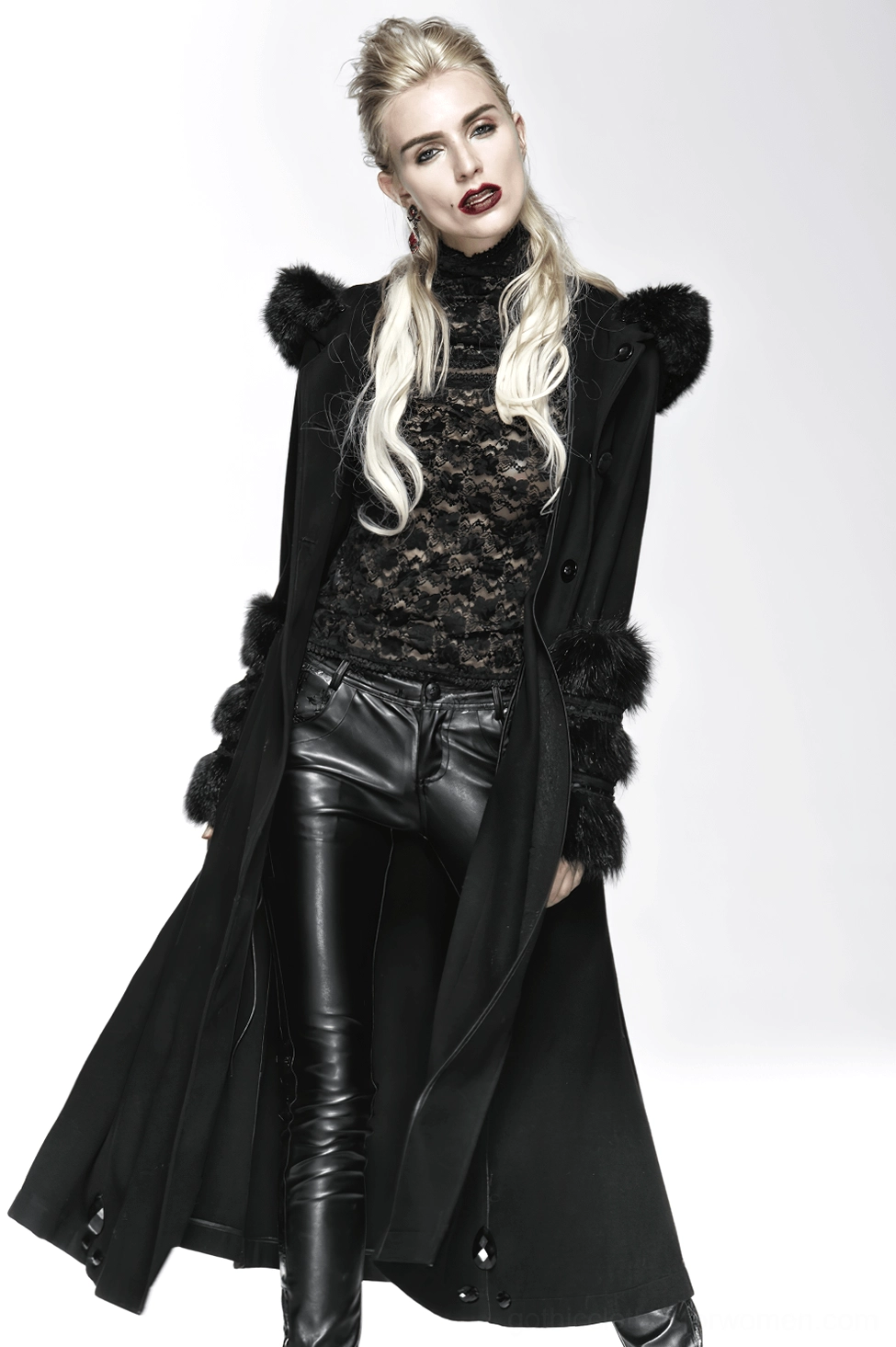 Model wearing black gothic hooded coat with faux fur cuffs and dramatic silhouette