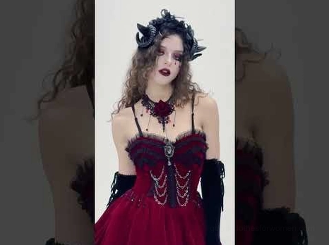 Gothic spiral horn headband styled with burgundy goth dress and chain choker on female model, dark aesthetic full view