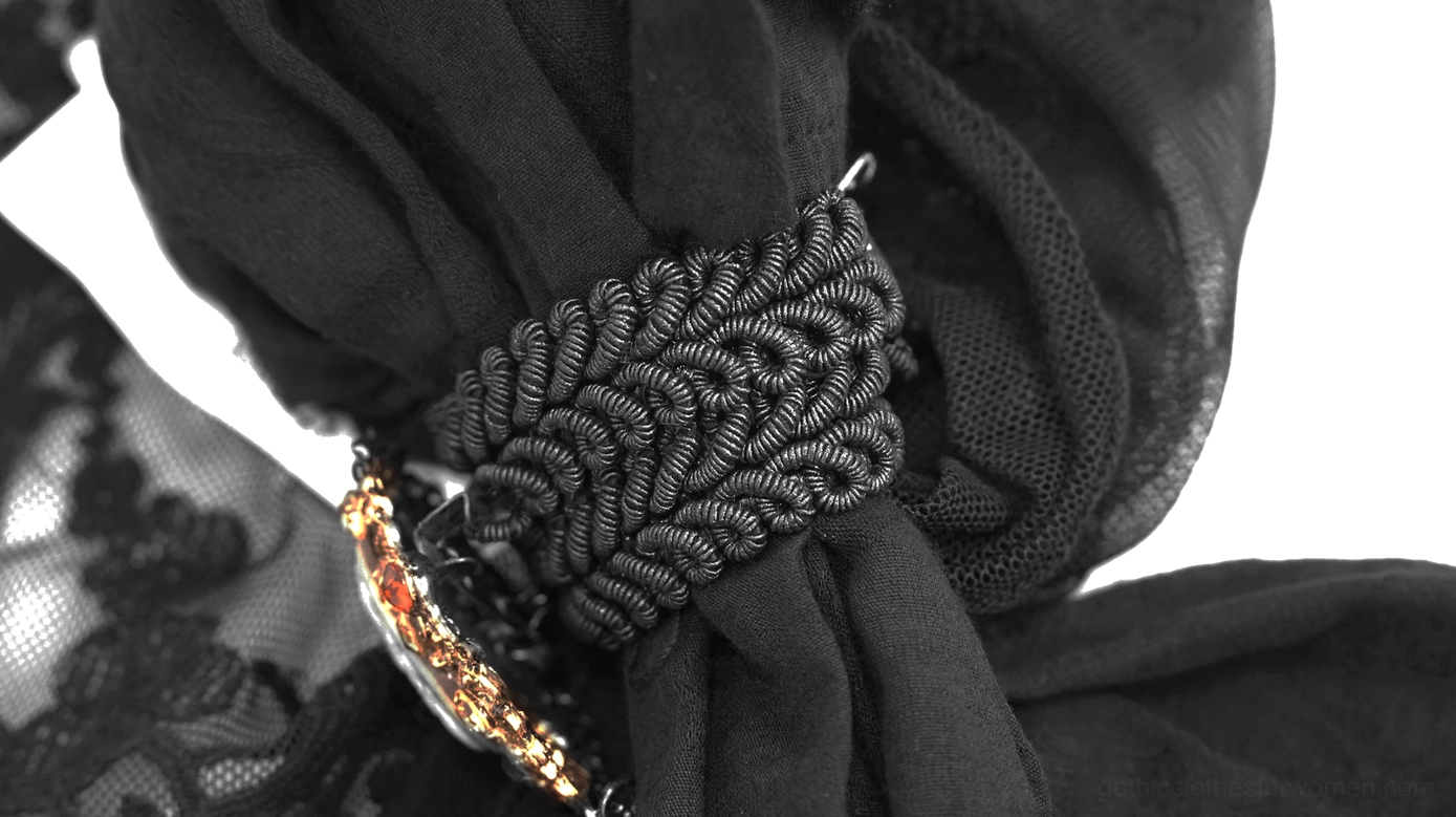 Side shot close-up of gothic jabot showing braided trim detail, gemstone charm, and metal brooch construction