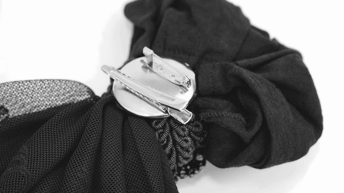 Back view close-up of gothic jabot tie revealing clip-on brooch fastener and black mesh fabric layers