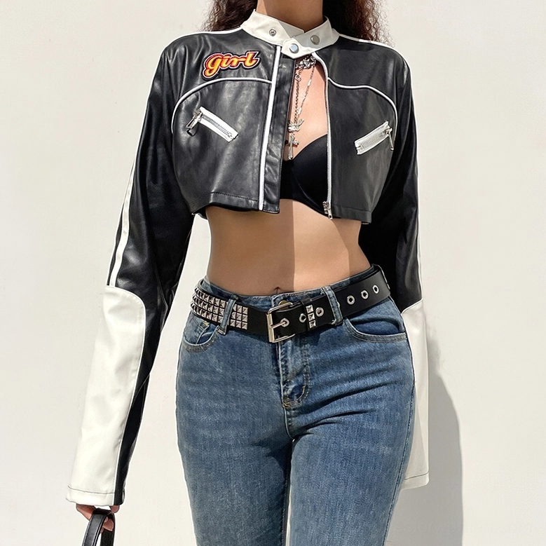 Low angle front view of black and white gothic cropped biker jacket on model wearing studded belt and cross necklace