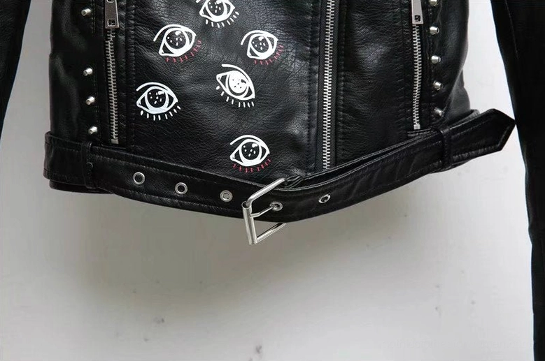 Close-up of black motorcycle jacket material texture PU leather quality with decorative print and stud detail