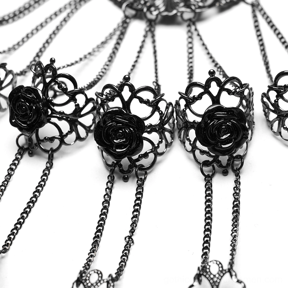 Top-down macro view of black enamel roses and filigree metal settings on gothic finger chain, connected with fine metal chains showing intricate detailing