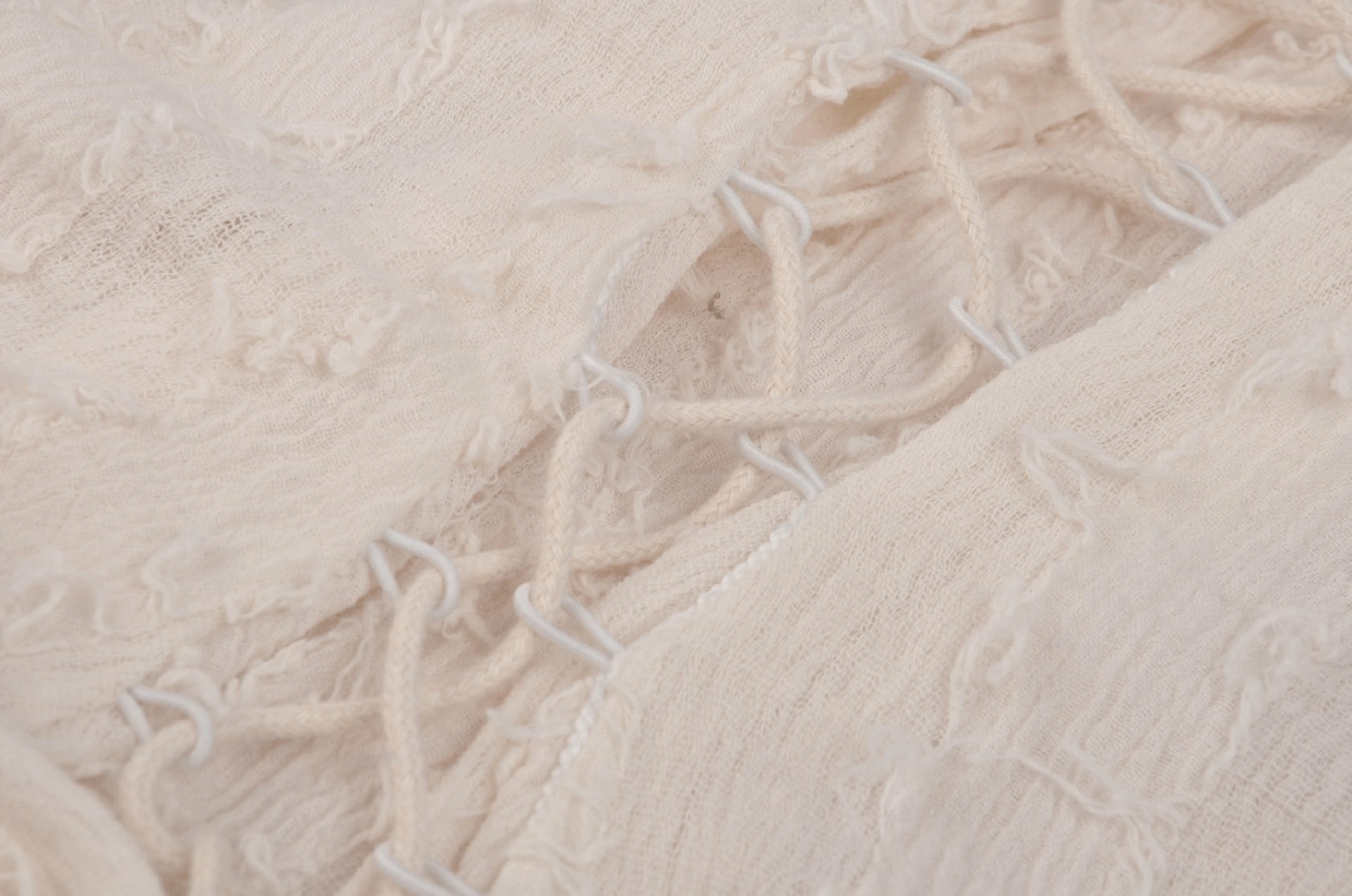 Close-up detail of cream corset fabric showing lace-up stitching and construction on gothic dress back