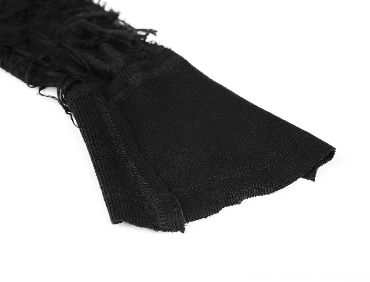 Close-up detail of black lace dress flared knit cuff with frayed lace trim and distressed edge