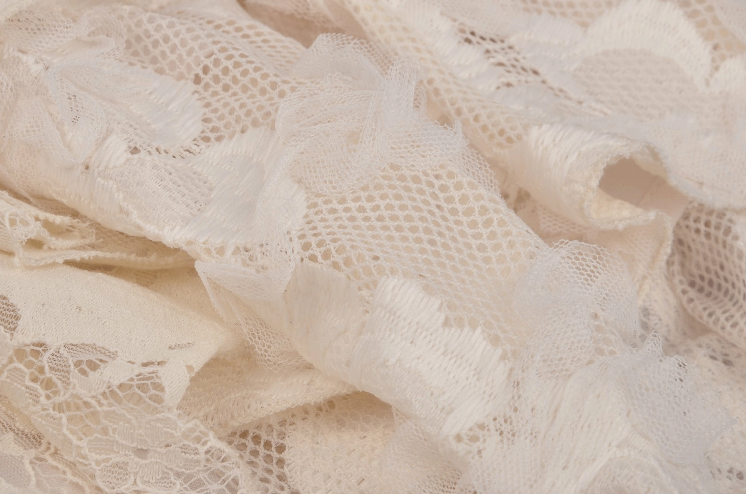 Close-up macro detail of cream floral embroidered mesh lace texture on gothic dress showing delicate pattern work