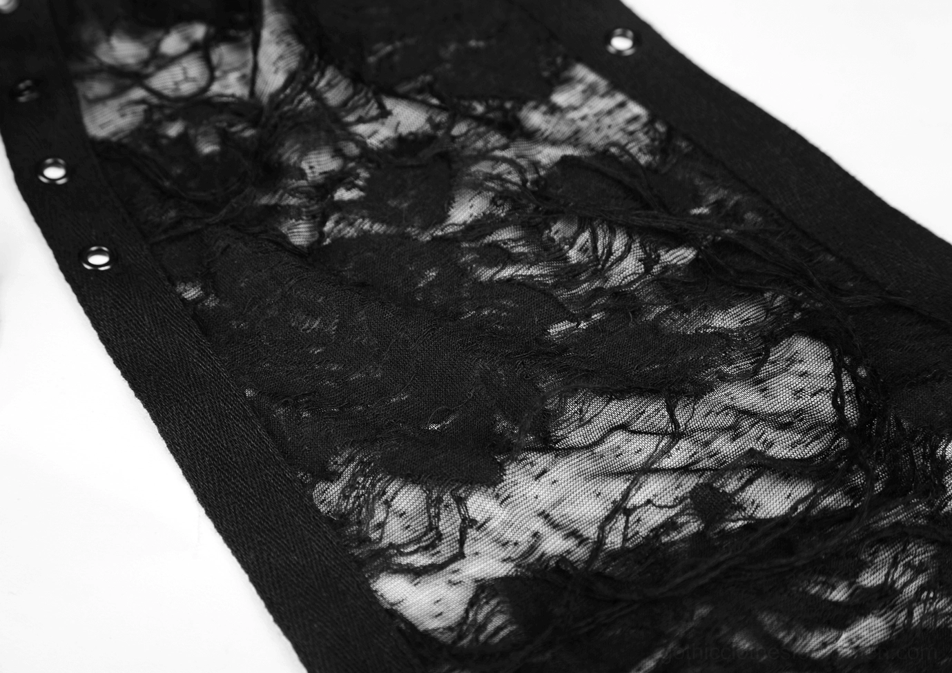 Fabric detail of black gothic lace showing distressed frayed texture and metal eyelet trim on seam