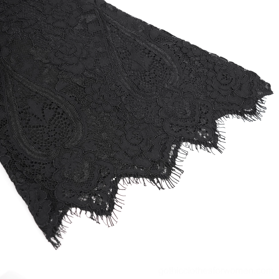 Close-up detail of black paisley floral lace fabric with scalloped edge on gothic dress