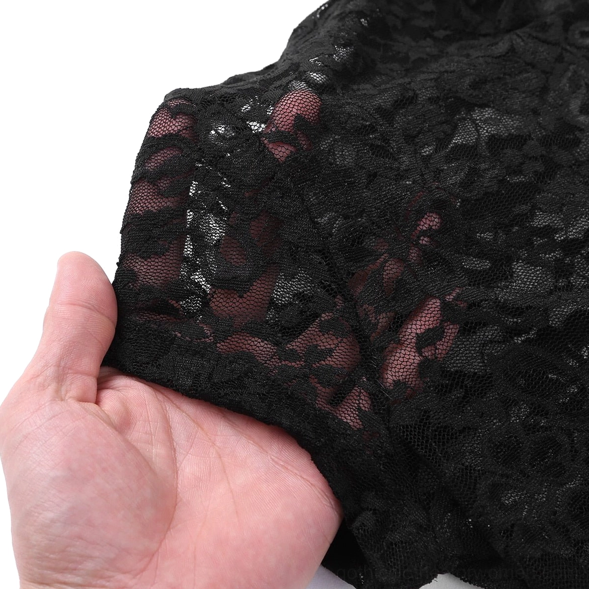 Sheer black floral lace fabric swatch texture detail, hand holding lace material showing transparent gothic pattern, fabric quality showcase