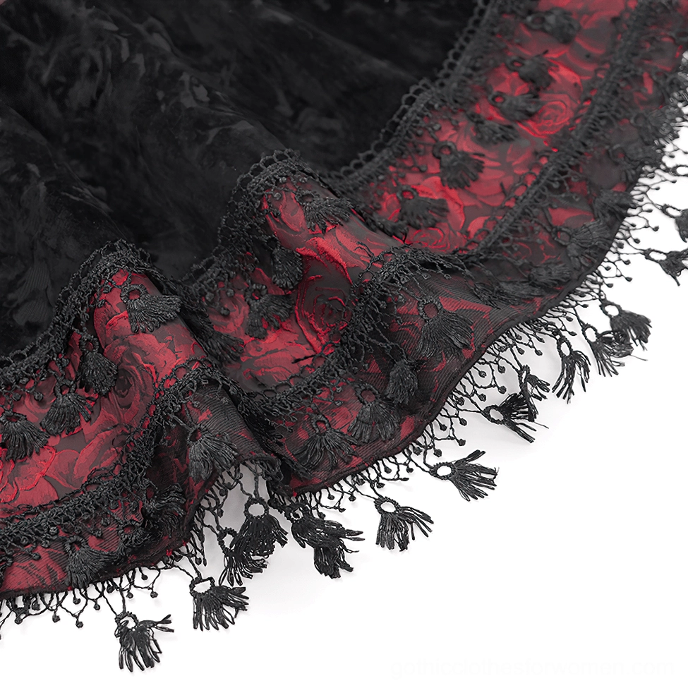 Close-up of gothic skirt hem showing black lace trim tassel pendants and red jacquard underlayer