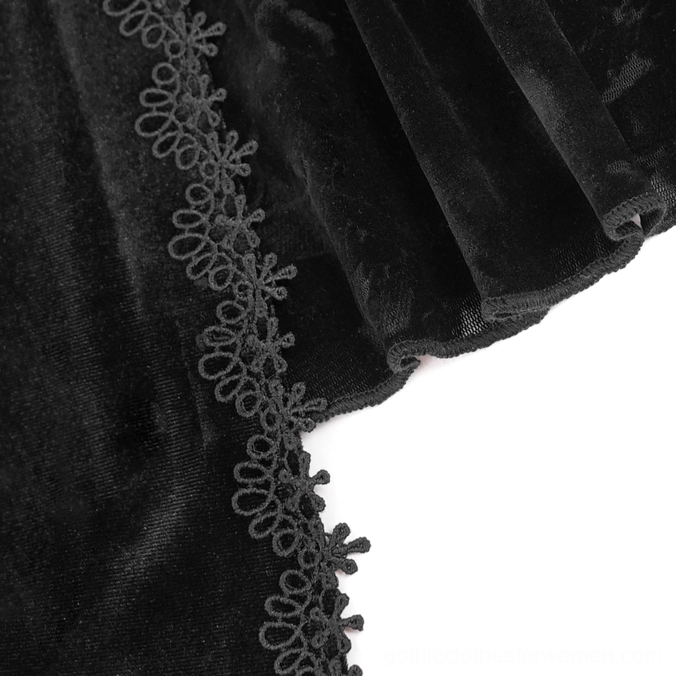 Close-up textile detail of gothic lace top showing black velvet and embroidered floral lace with fine stitching