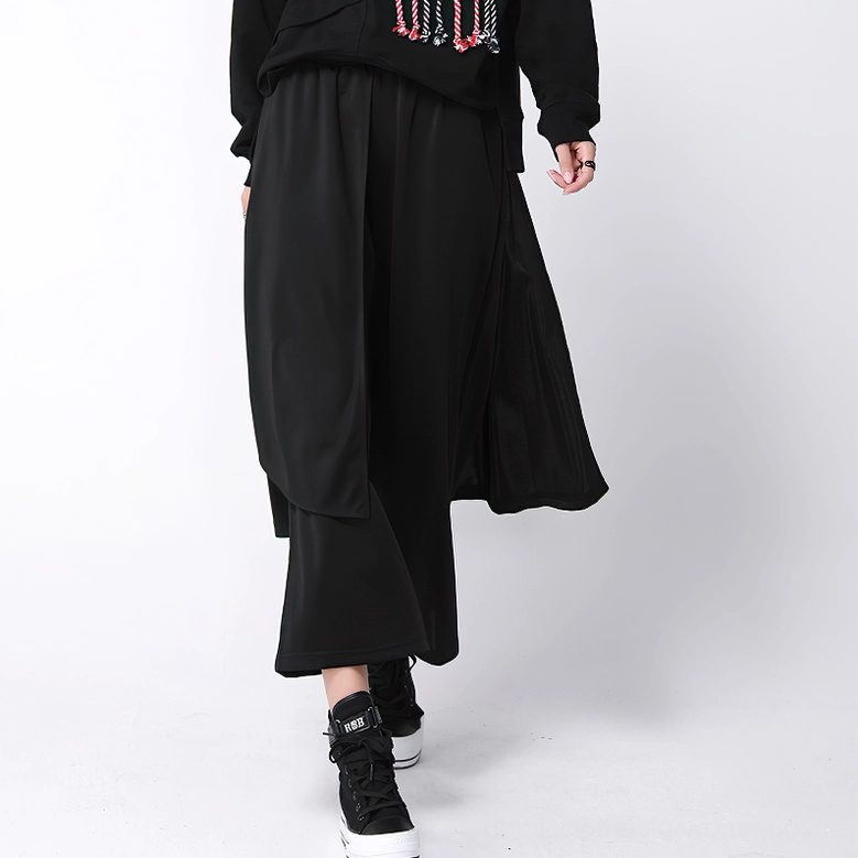 Gothic wide-leg trousers with elastic waist and flowing layered drape, side oblique styling view