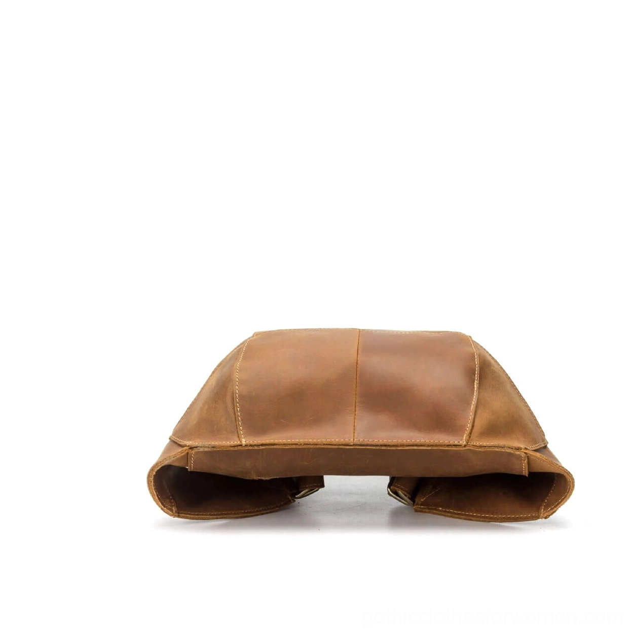 Folded tan leather gothic backpack top-down flat lay view on white background