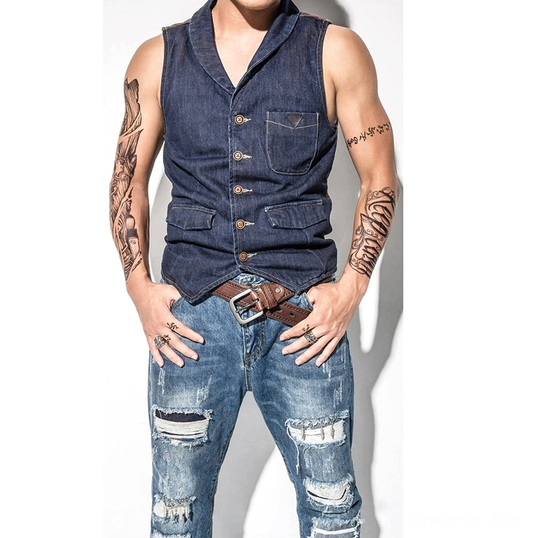 Styled wear shot: tattooed male model wearing brown leather gothic belt with denim casual outfit showcasing alternative rock aesthetic