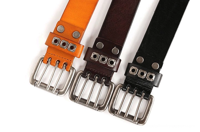 Comparison of three gothic studded leather belts in black, dark brown, and orange with single-prong silver buckles