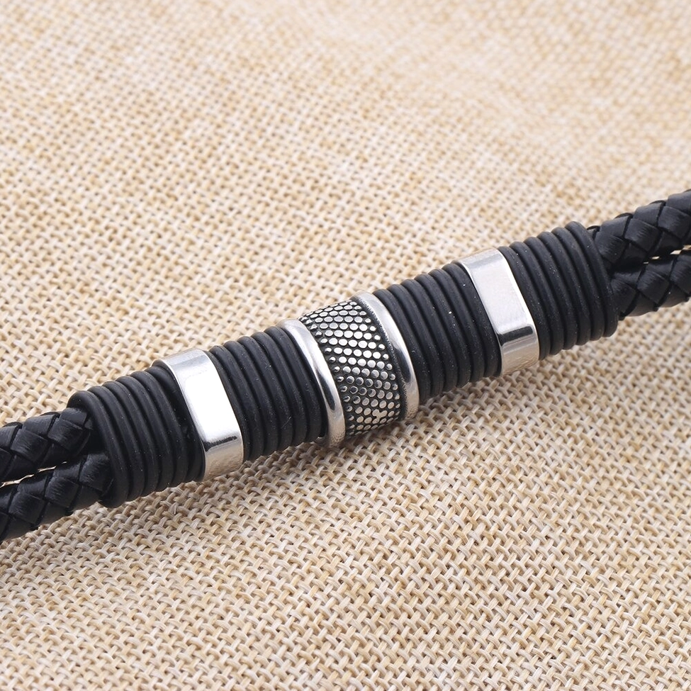 Side view close-up of braided leather texture and stainless steel hardware on gothic bracelet