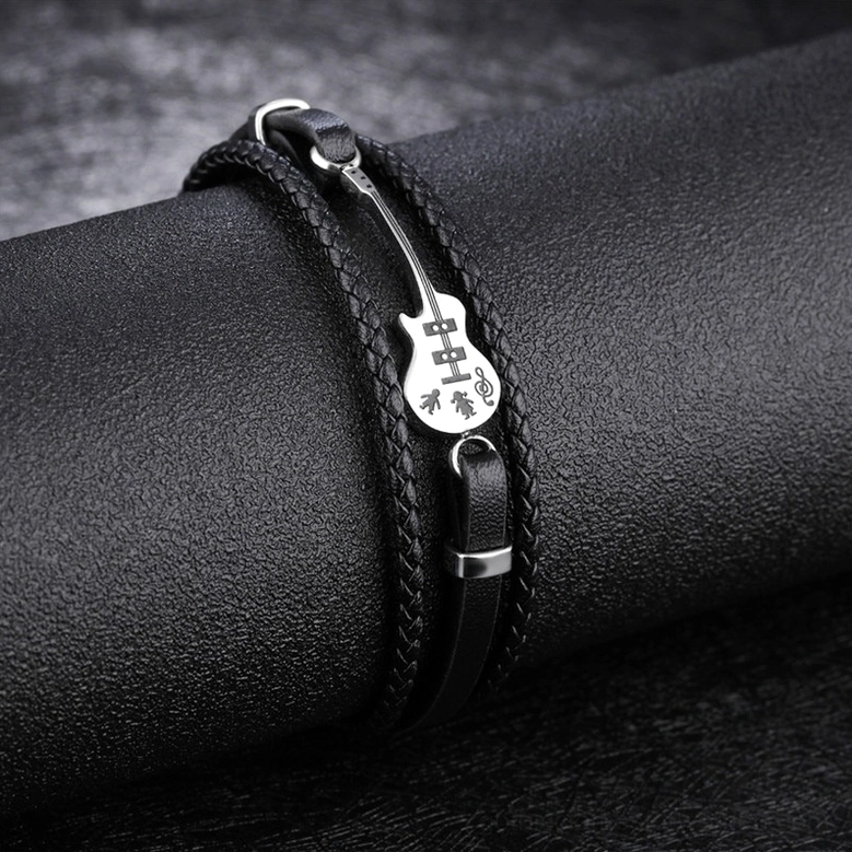 Close-up detail of gothic multilayer leather bracelet showing genuine leather texture, stitching, and metal guitar charm