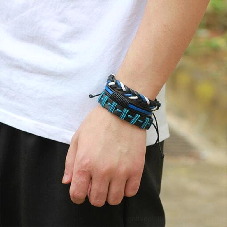Black and blue gothic leather braided bracelets worn on male wrist, outdoor casual styling