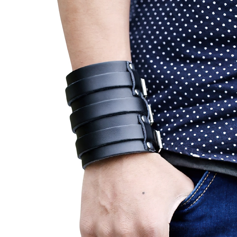 Close-up side view of leather gothic cuff bracelet worn on wrist showing triple strap configuration with silver buckles