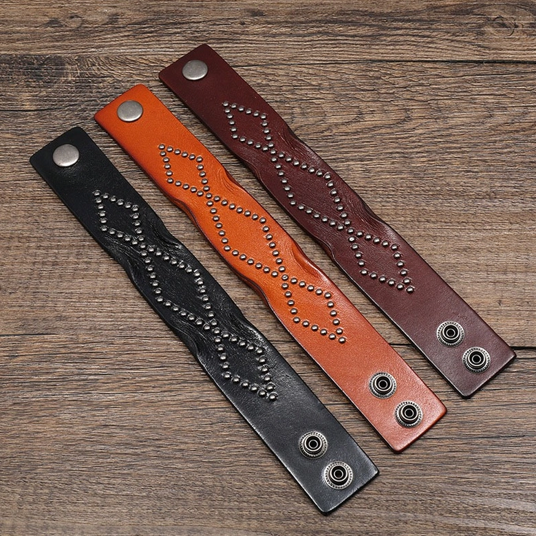 Wide leather cuff bracelet straps in three gothic color options - black, brown, wine red - showing geometric rivet patterns and snap fasteners in flat lay arrangement
