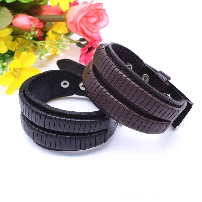 Dual gothic leather cuff bracelets front view with floral botanical backdrop styling both black and brown variants
