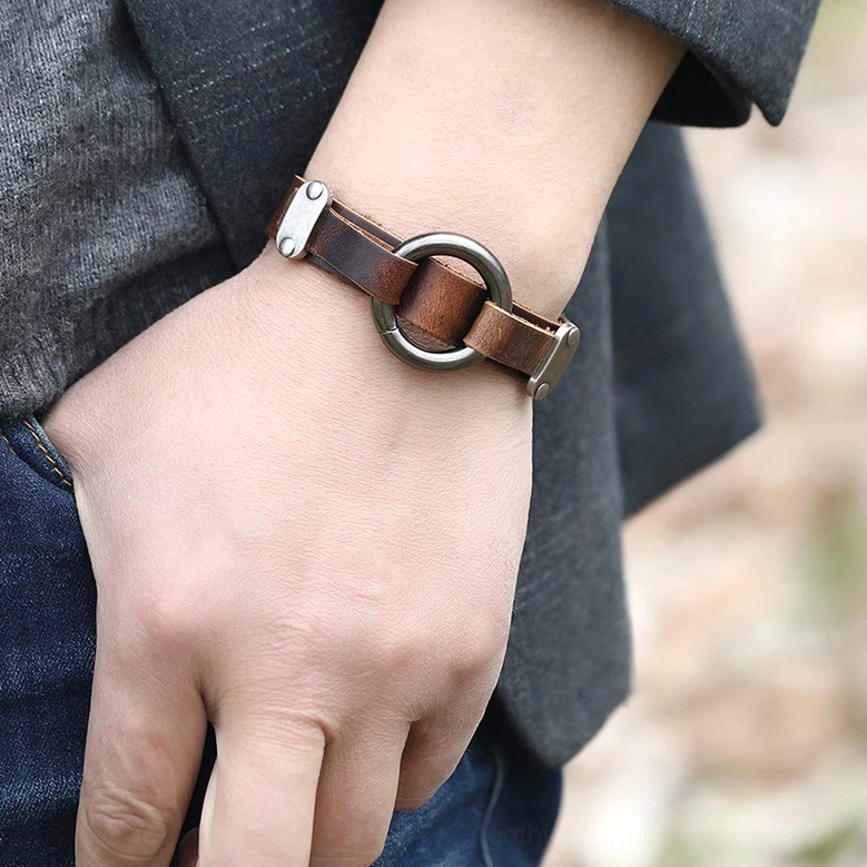 Male model wearing distressed leather gothic cuff bracelet on wrist with casual outdoor styling, demonstrating real-world wear and unisex aesthetic