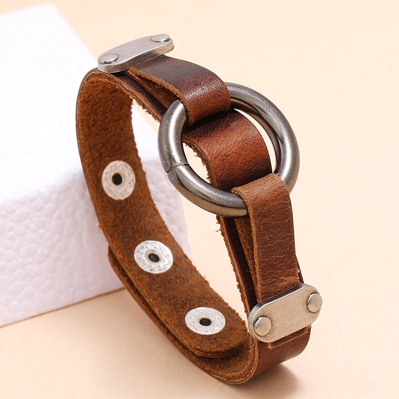 Distressed brown leather gothic cuff bracelet on display, side angle view showcasing rivet-style snap buttons and dark antique metal hardware