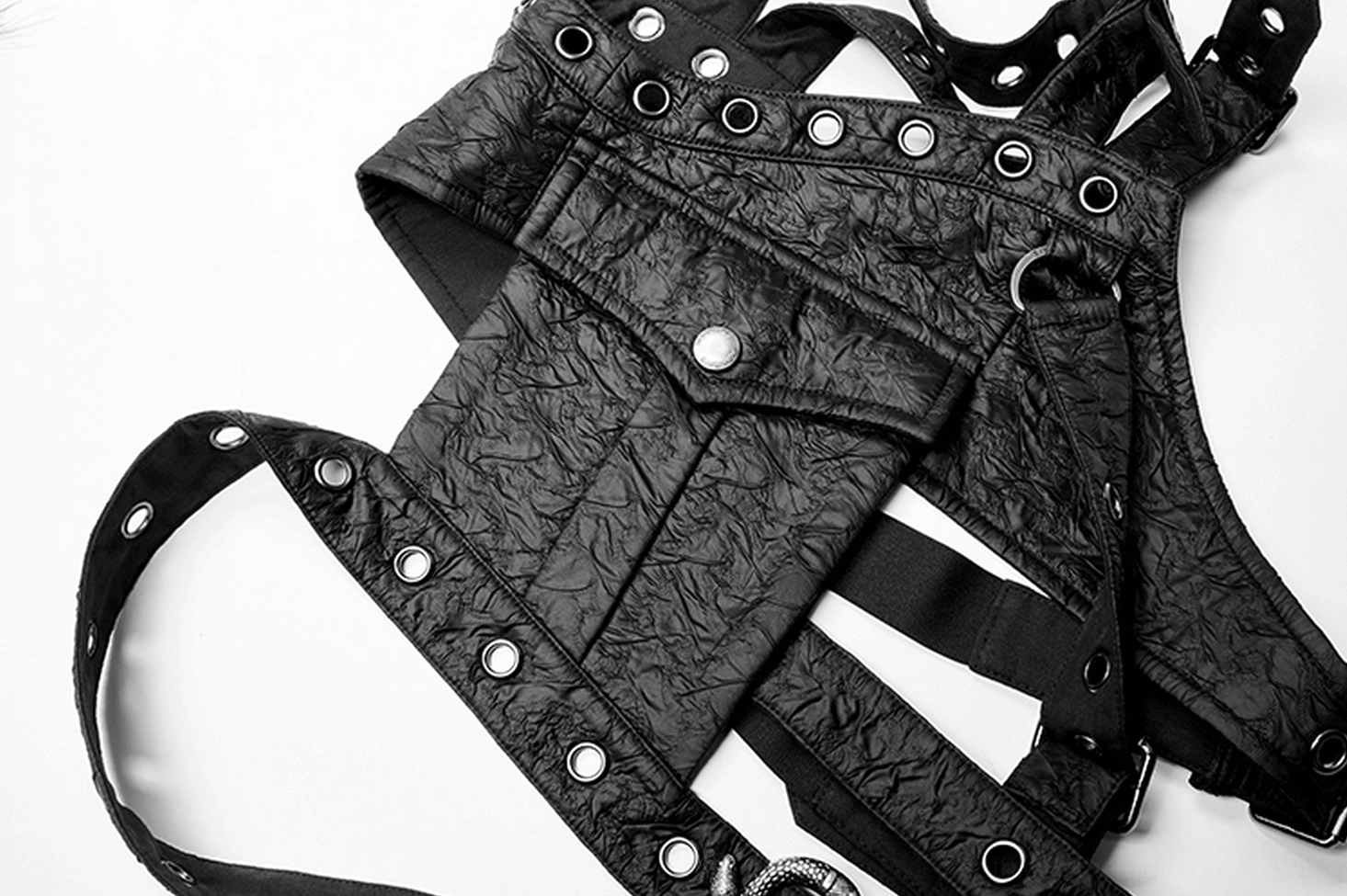 Overhead flat lay of complete black leather shoulder harness showing multi-strap tactical design with metal studs