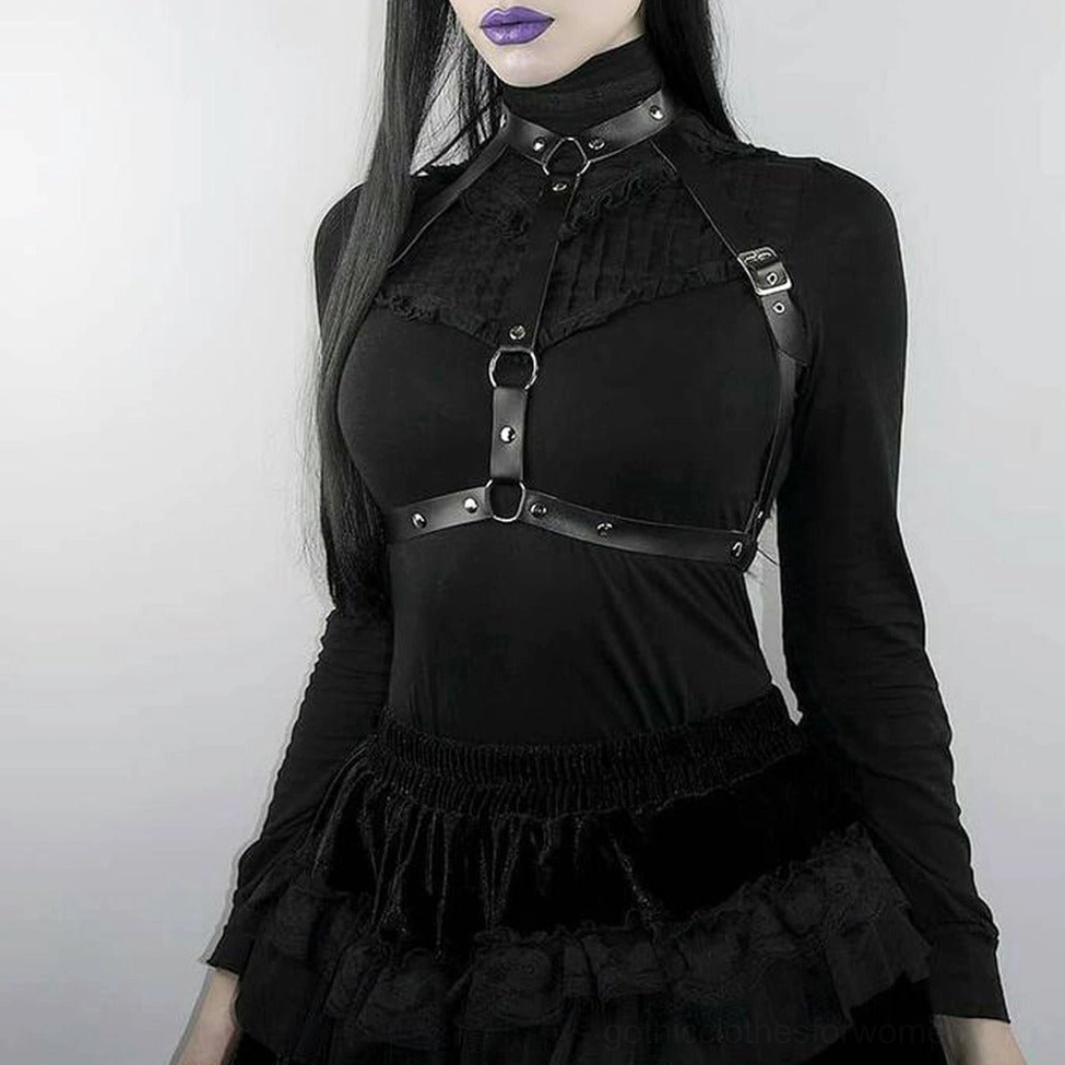 Female goth model with purple lipstick wearing black PU leather chest harness, front three-quarter view demonstrating styling and wearability