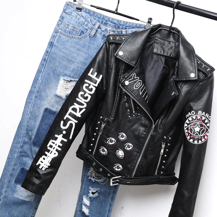 Black faux leather motorcycle jacket paired with distressed blue denim three-quarter side view on hanging clothing display