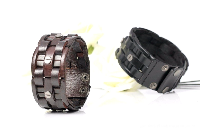 Two gothic leather wrap bracelets in black and coffee brown, flat lay with white roses, showing dual color styling options