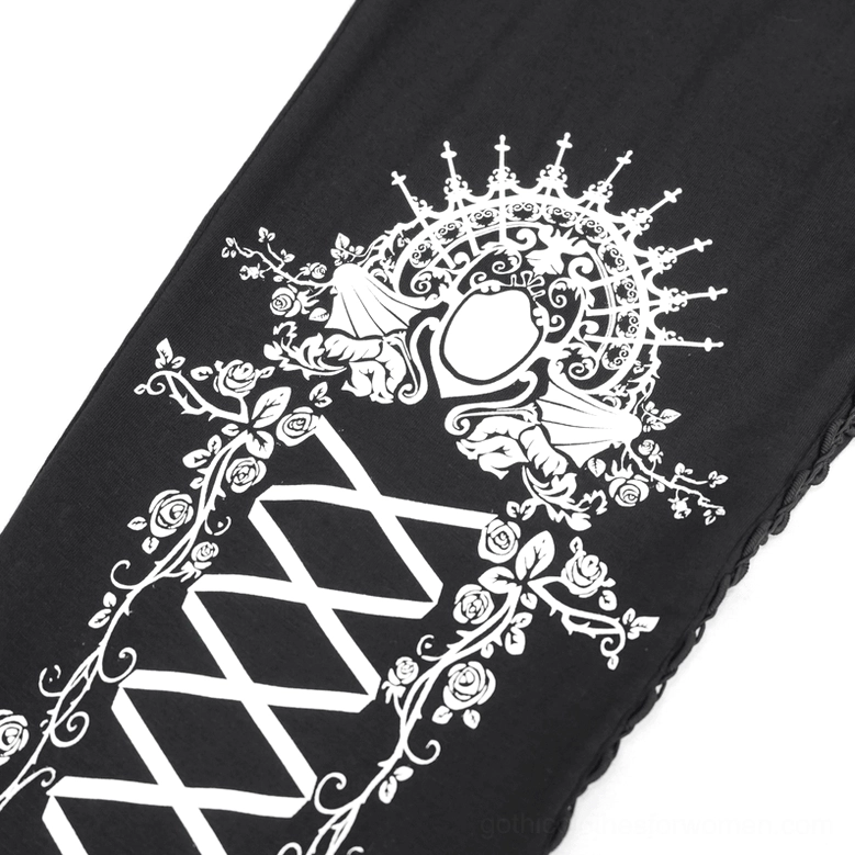 Close-up of white royal gothic crest and ornamental rose vine prints on black leggings fabric