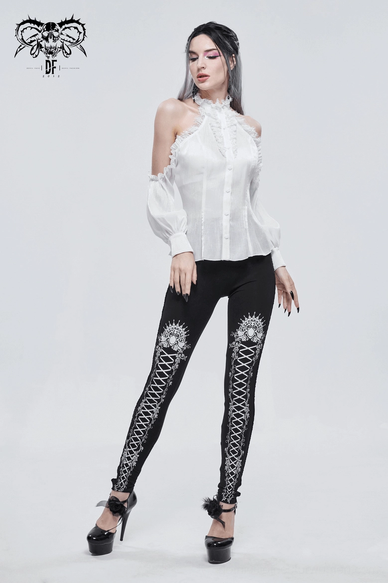 Black gothic patterned leggings close-up showing white royal crest and ornamental rose vine motifs