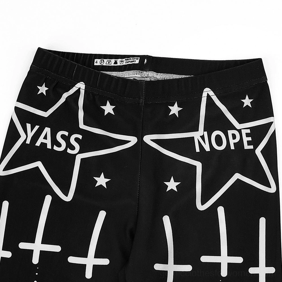 Close-up waist section of witchcraft leggings displaying elastic waistband with stars, crosses and slogan prints